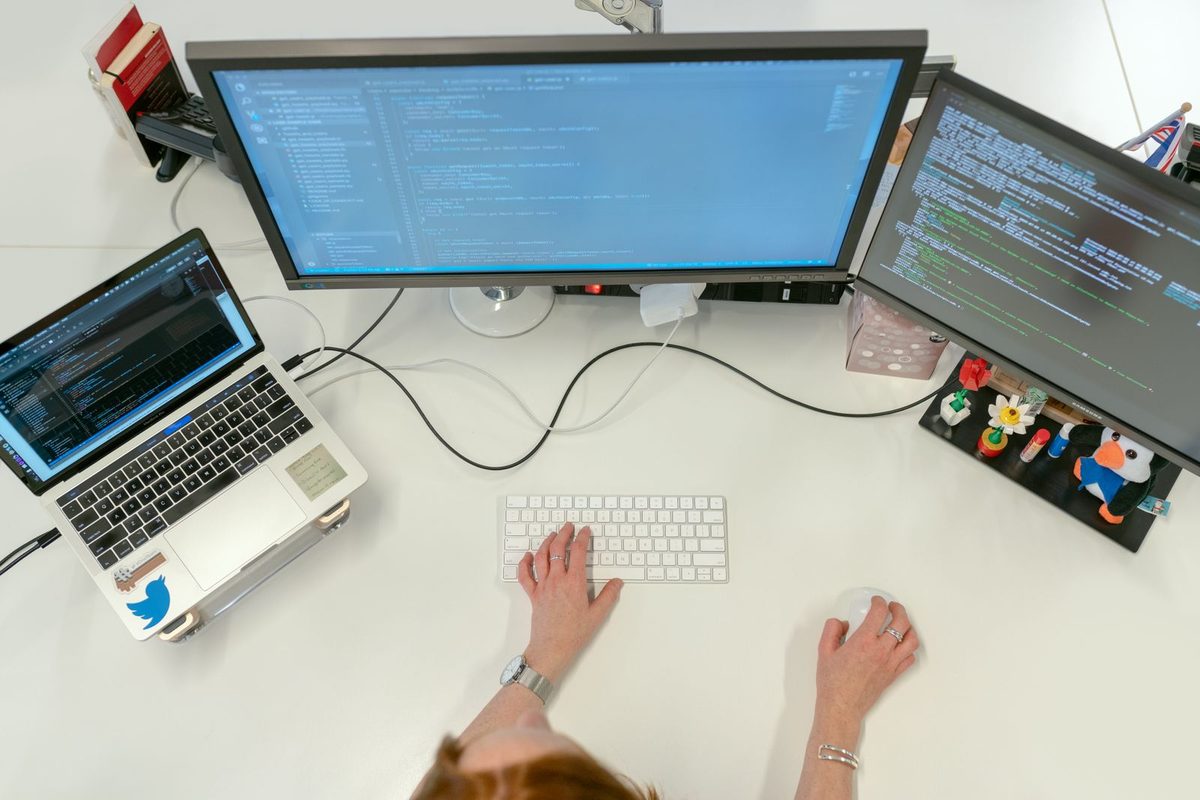 A Vasuki Indicus engineer building and automating cloud infrastructure and CI/CD pipelines on multiple screens