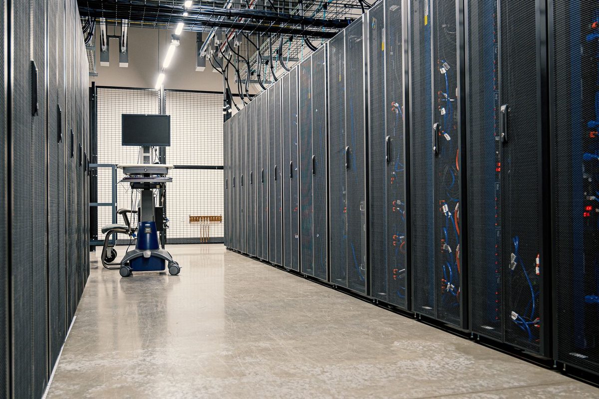 A data-center aisle of server racks — the systems and databases Vasuki Indicus administers and tunes
